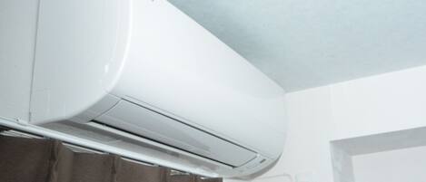 Un equipo de aire acondicionado blanco montado en la pared de un baño.