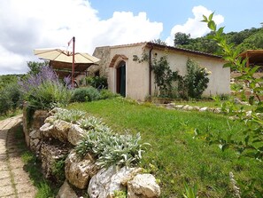Guesthouse surrounded by a lush garden with a traditional archway entrance.
