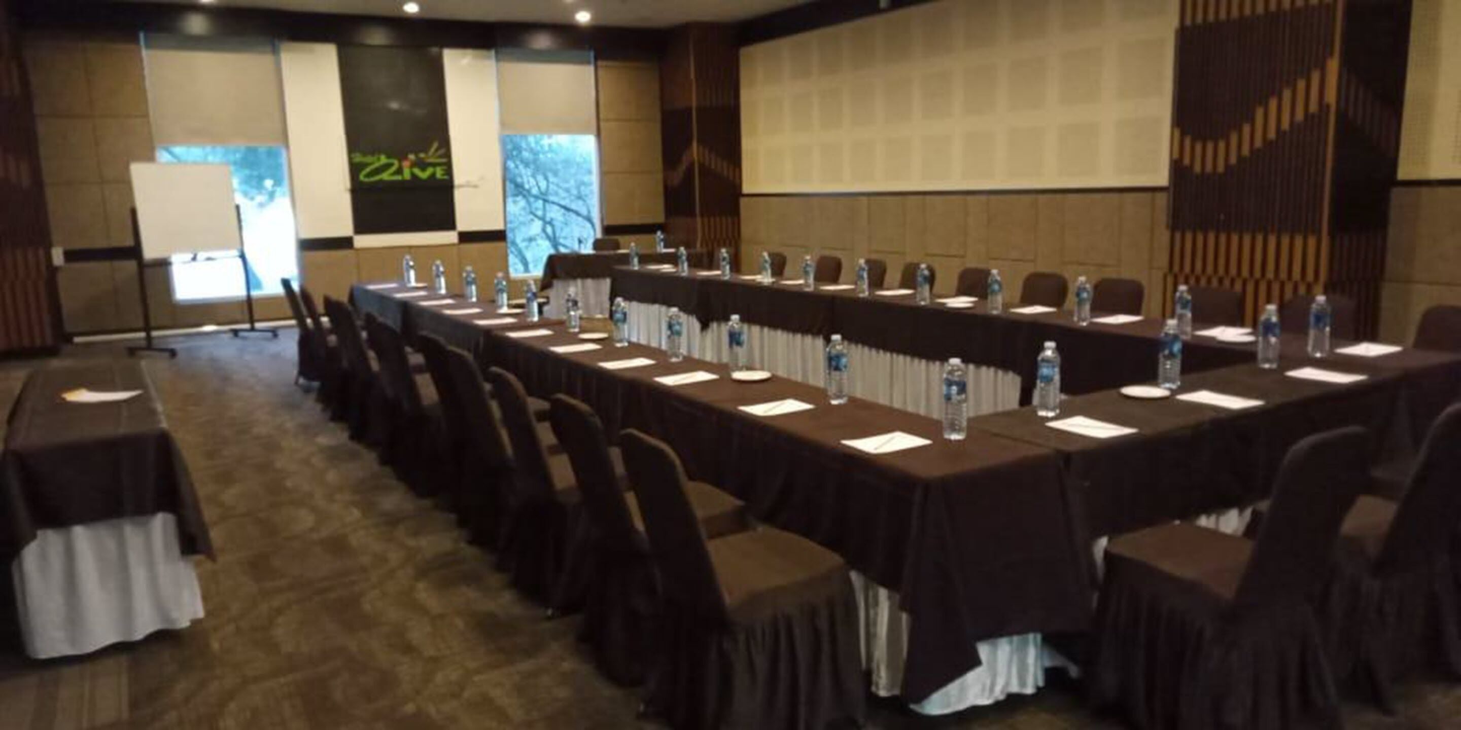 A conference room with long tables, chairs, and water bottles.