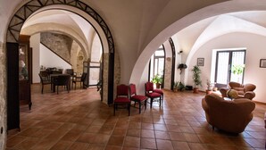 A spacious interior with arched ceilings, a dining area, and several seating options. - B&B Sotto le Stelle (Caltabellotta)