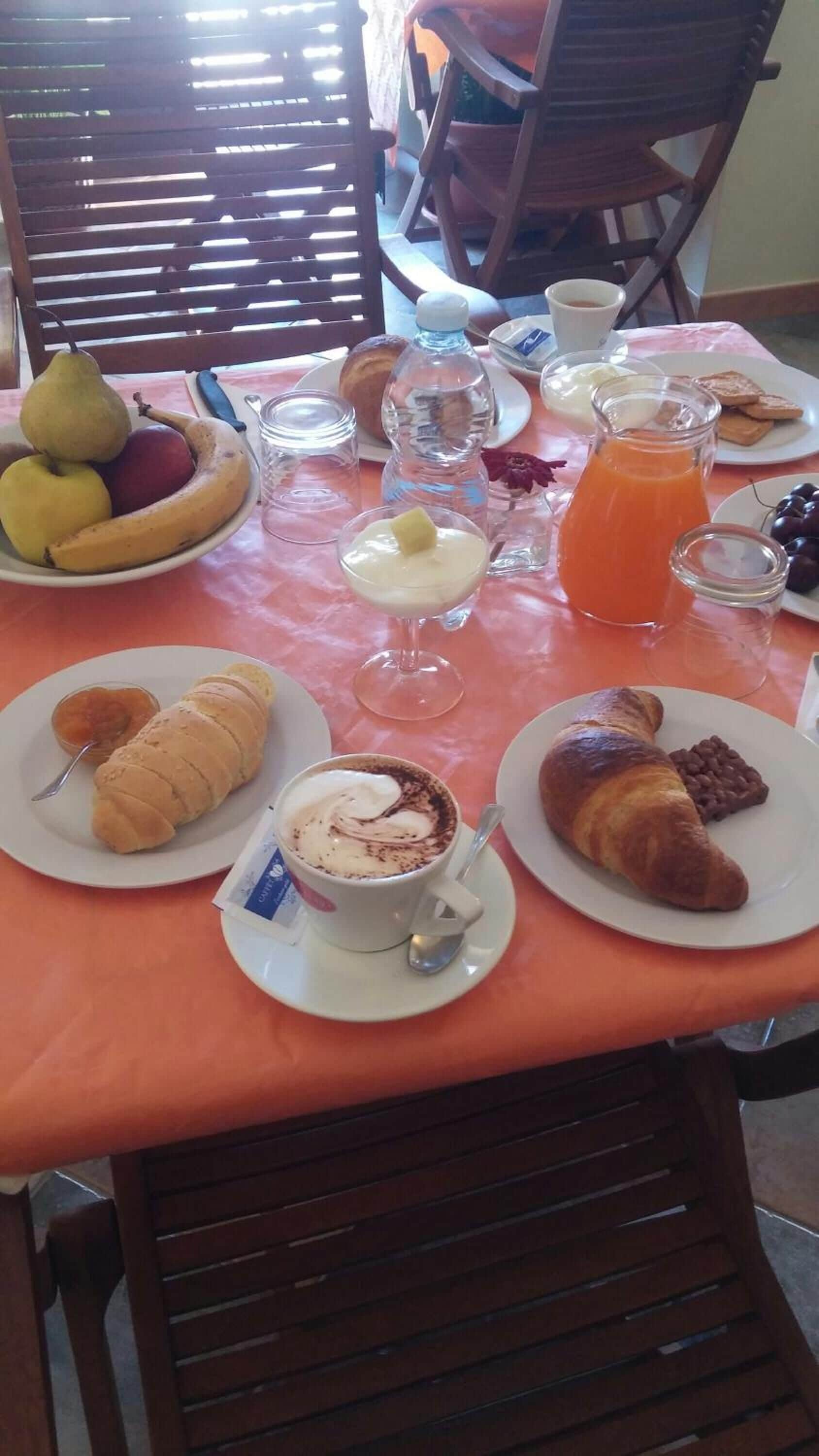 Une table de petit-déjeuner avec des assiettes de nourriture, notamment des croissants, un croissant au chocolat, un verre de jus d'orange, un verre de lait, un verre d'eau, un verre de jus, un verre de lait, un verre de jus, un verre de lait, un verre de jus, un verre de lait, un verre de jus, un verre de lait, un verre de jus, un verre de lait, un verre de jus, un verre de lait, un verre de jus, un verre de lait, un verre de jus, un verre de lait, un verre de jus, un verre de lait, un verre de jus, un verre de lait, un verre de jus, un verre de lait, un verre de jus, un verre de lait, un verre de jus, un verre de lait, un verre de jus, un verre de lait, un verre de jus, un verre de lait, un verre de