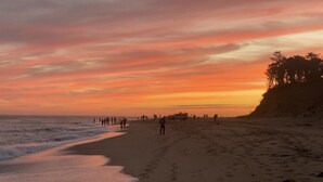 A beach with people walking along the shore during sunset. - Pristine Chappy! August 29 through Labor Day 2026 Available !  (Chappaquiddick Island, Edgartown)