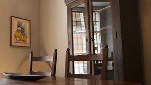 A dining table with a chair, a framed picture on the wall, and a wooden cabinet with glass doors. - Casa Magnolia (Verona)
