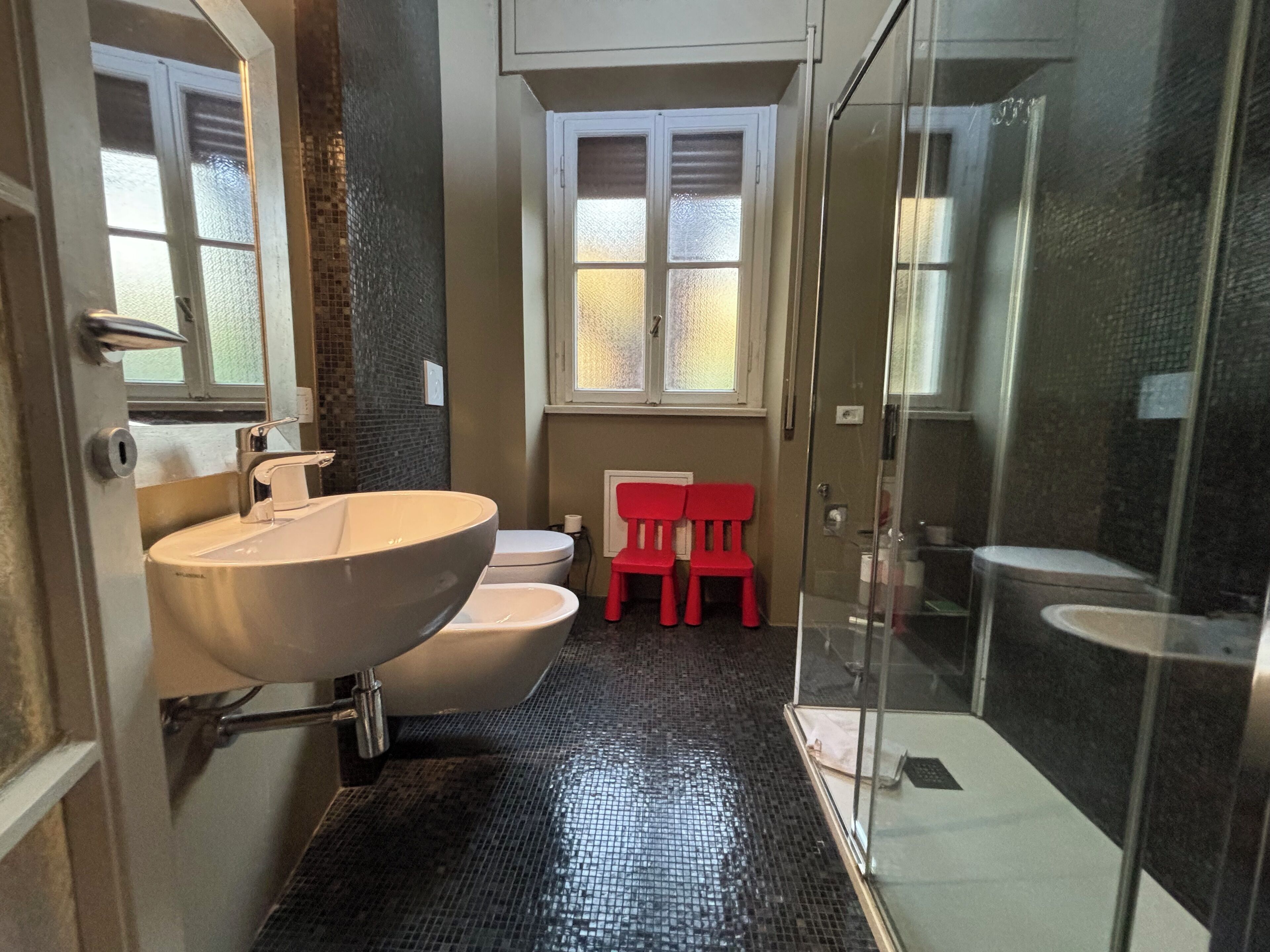 Baño con lavamanos grande, inodoro y zona de ducha.