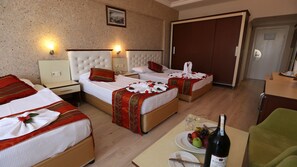 A hotel room with two beds, a dining table with plates and a bottle of wine, and a wardrobe. - Mysea Hotels Incekum (Alanya)