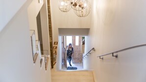 A staircase with a modern design, a wooden floor, and a metal handrail. - Amymone Suites (Nafplio)