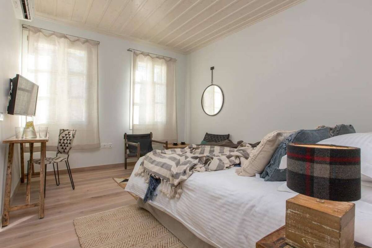 Une chambre à coucher avec un lit, un bureau, une chaise et un miroir.