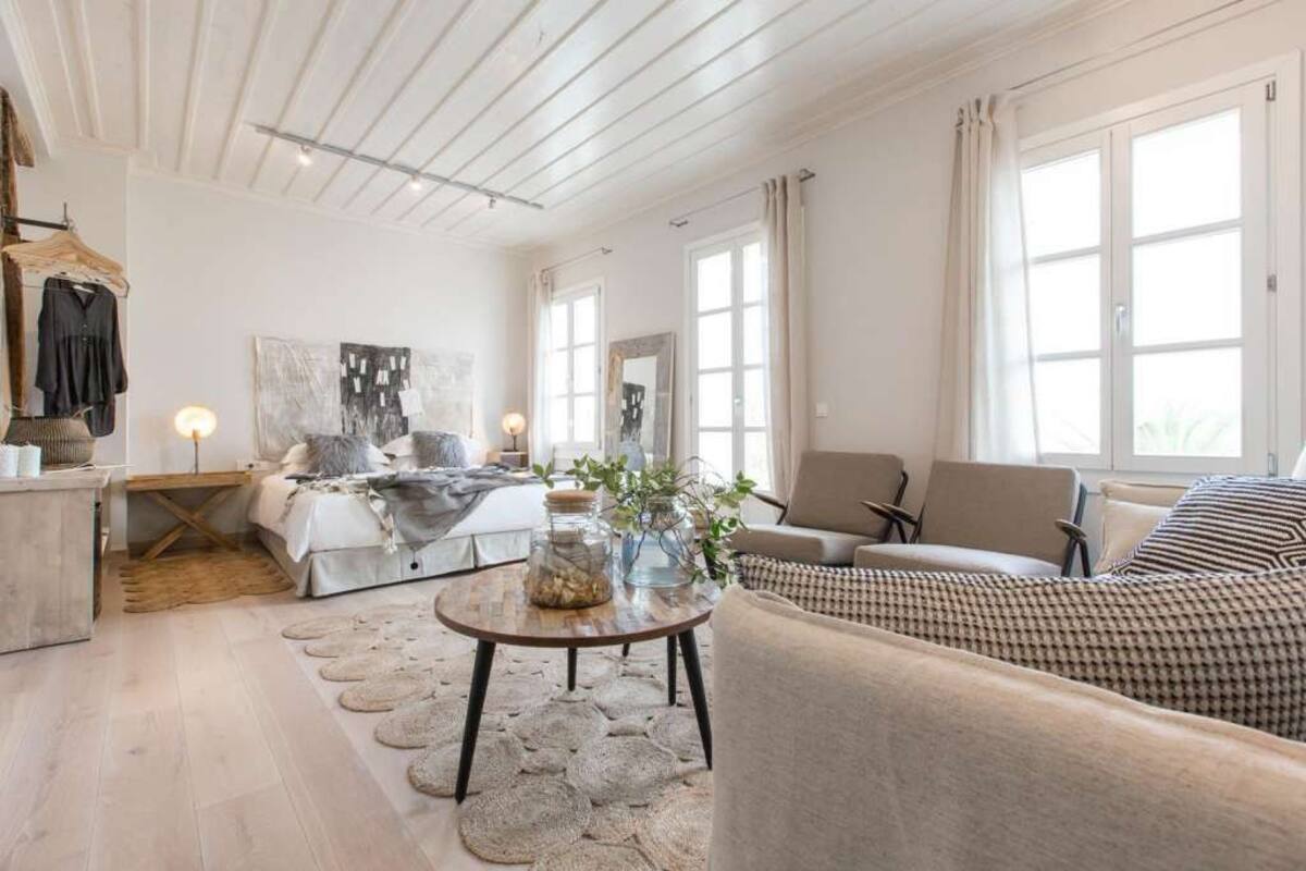 Un salon spacieux doté d’une grande fenêtre, d’un canapé, d’une table basse et d’un lit offrant une vue agréable.