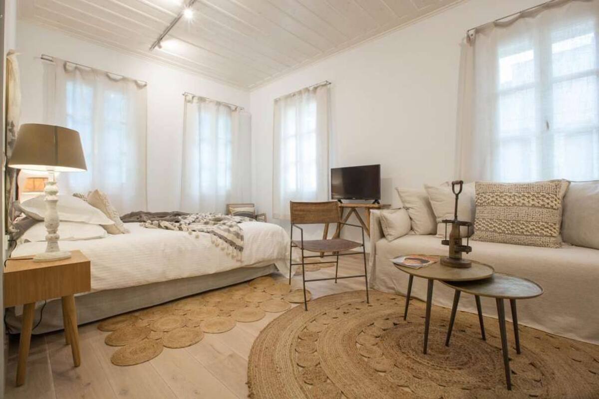 Une chambre confortable avec un lit, une télévision, un canapé et une petite table.