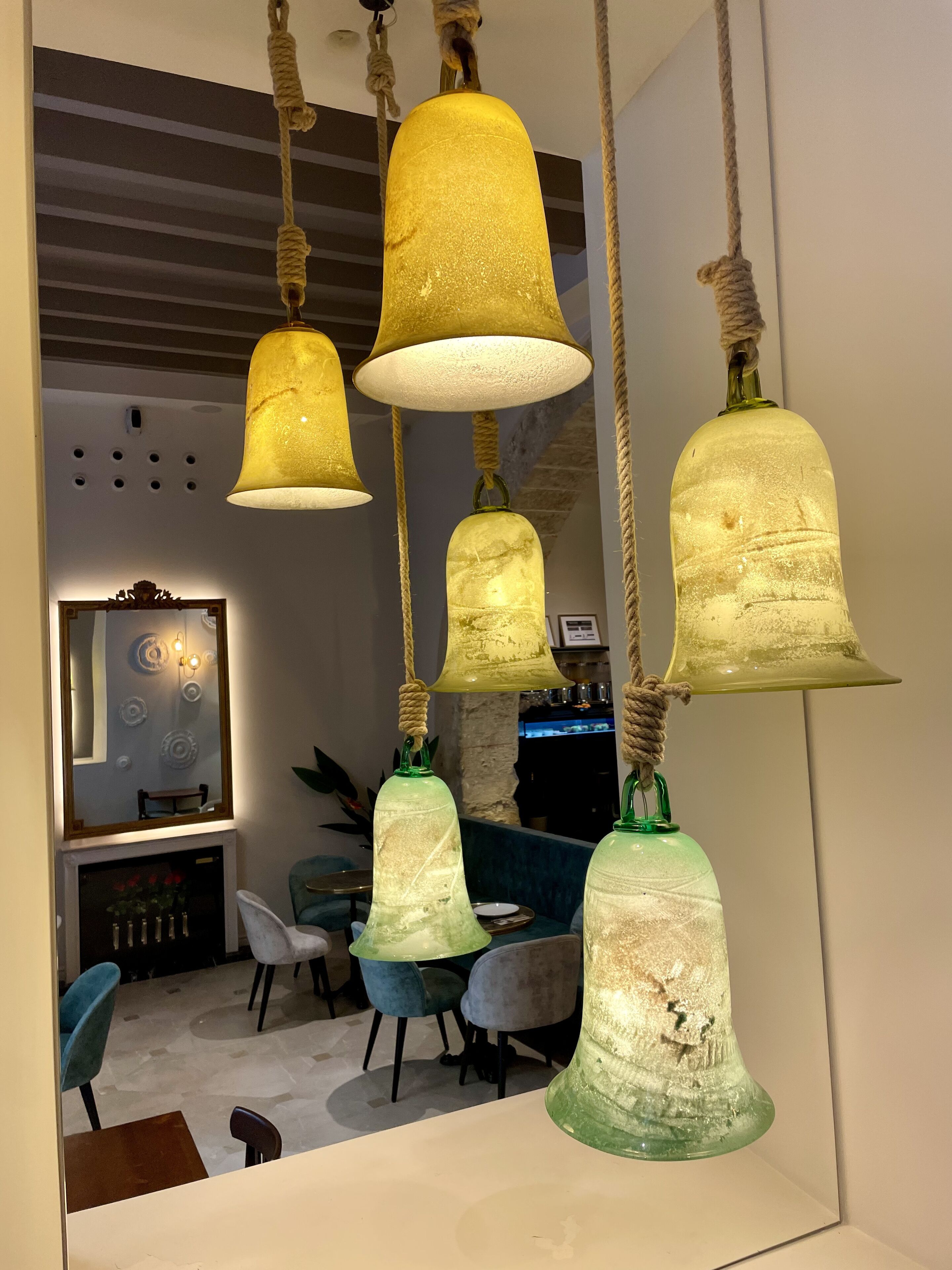 Una habitación con lámparas colgantes, un espejo y una zona de bar.