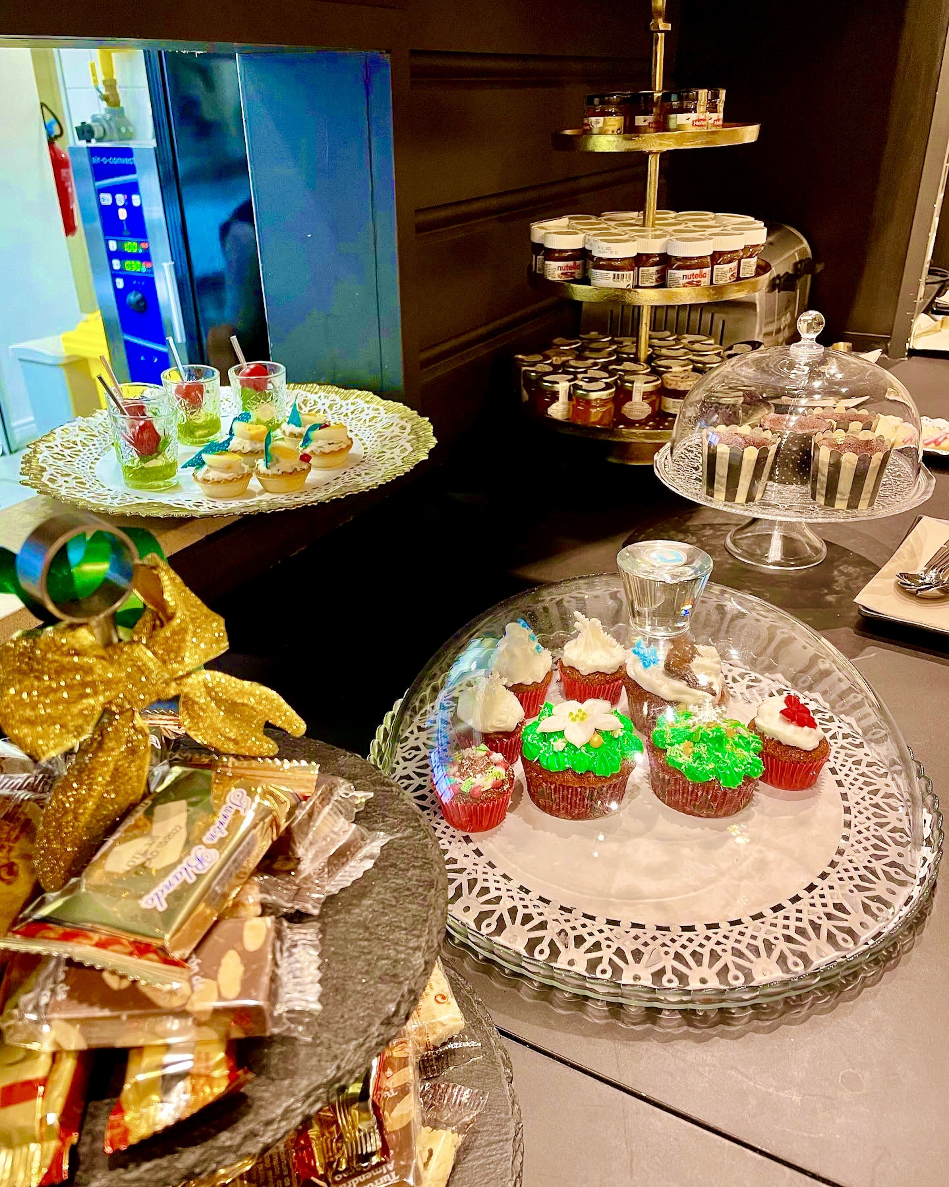 Una mesa de buffet con diversos postres y bocadillos, incluyendo cupcakes y barras de chocolate.