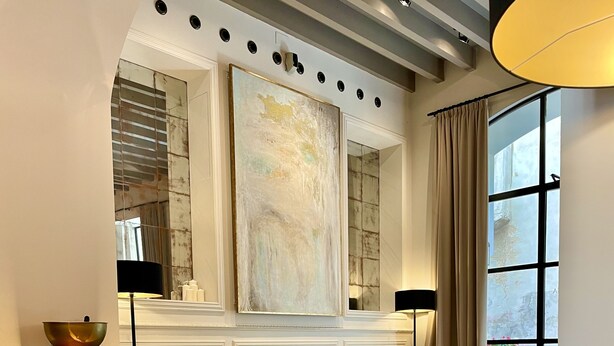 A lobby with a checkered floor, a green sofa, a glass table with a champagne glass, and a magazine on a table. - Hotel Basílica (Palma de Mallorca)