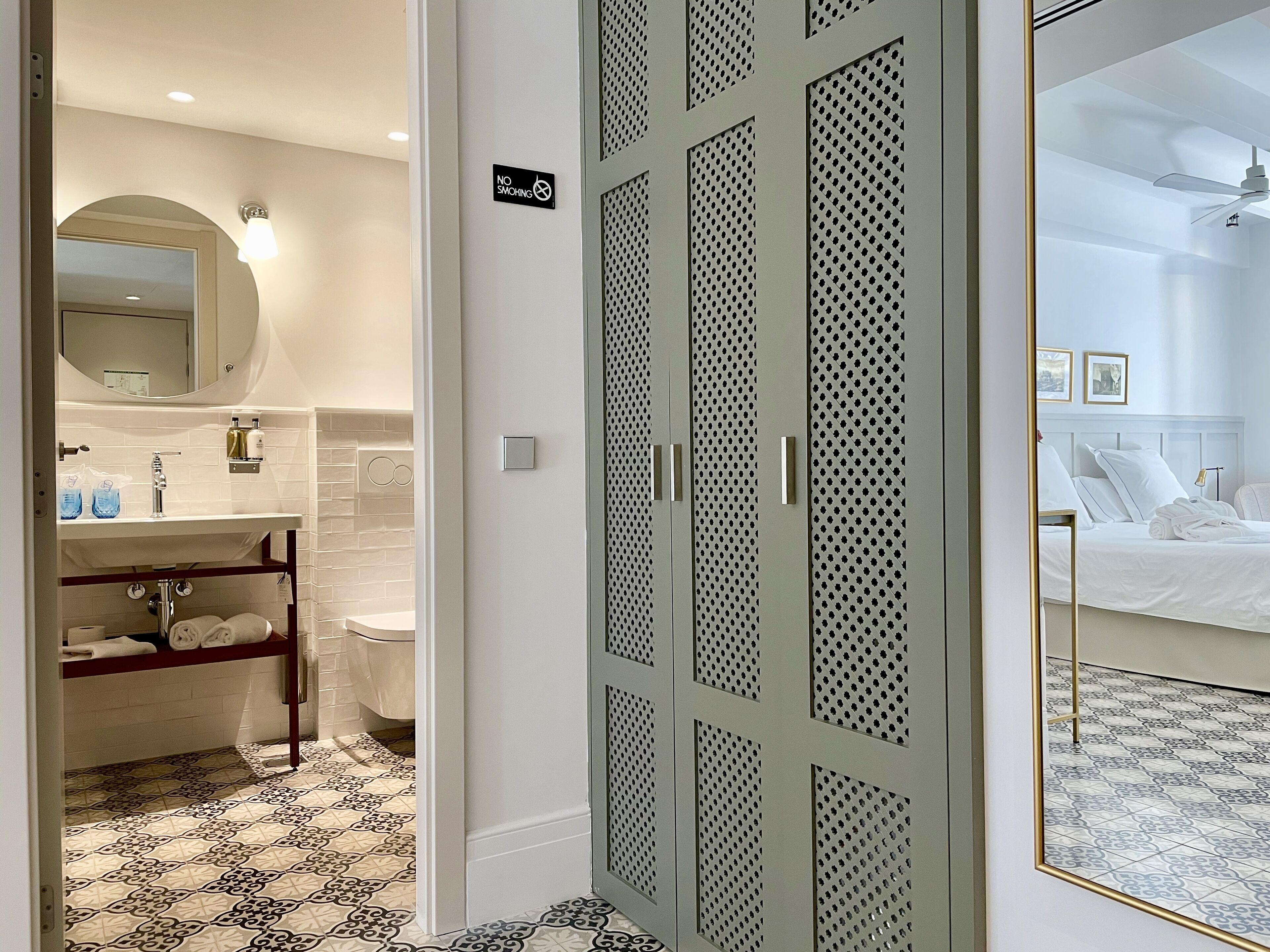 Une salle de bain d’hôtel équipée d’un lavabo, d’un miroir et d’un porte-serviettes.