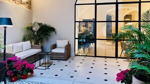 A spacious patio with a white sofa, a small table, and potted plants. - Hotel Basílica (Palma de Mallorca)