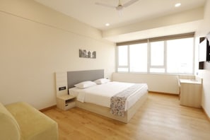 Un dormitorio moderno con cama, mesita de noche y ventana.