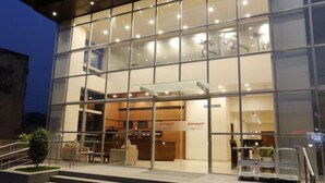 A modern building with a glass facade, a reception area, and a staircase leading to the entrance. - Ginger Aurangabad (Chhatrapati Sambhajinagar)