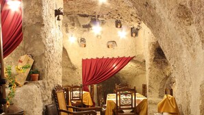 Un comedor rústico con paredes de piedra, mesas y sillas de madera.