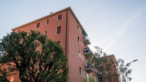 A multi-story brick building with balconies and windows.