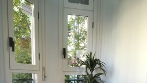 Una habitación de esquina con una silla blanca, una planta en maceta y un radiador.