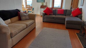 A living room with a sofa, a smaller sofa, and a rug. - Gowan Bank (Montrose)