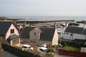 A coastal residential area with houses, a road, and a marina with boats. - Gowan Bank (Montrose)