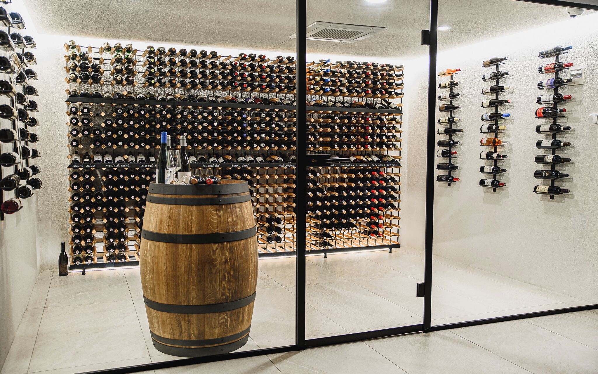 A wine cellar with numerous bottles organized on shelves and racks.