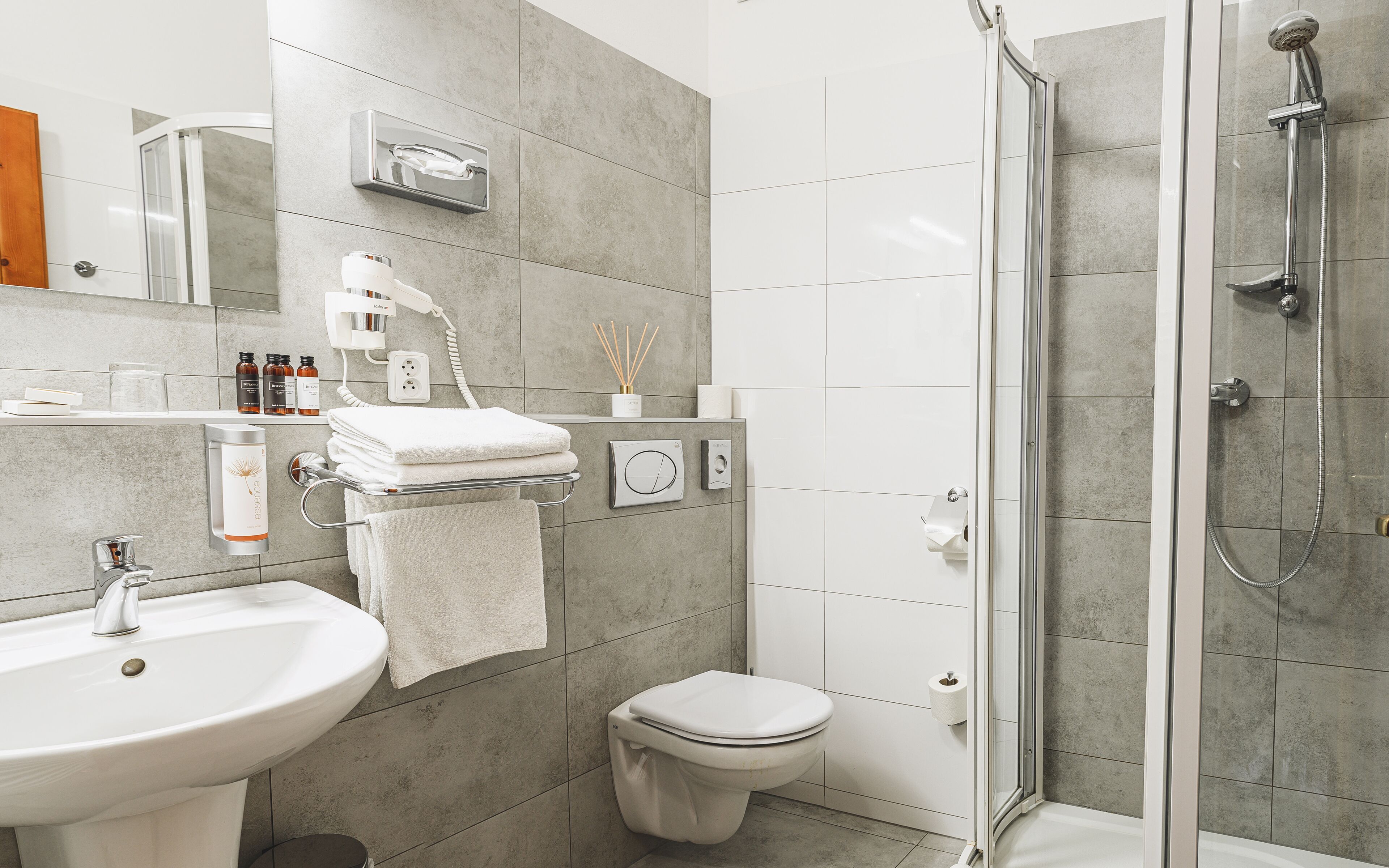 A modern bathroom with a sink, toilet, and shower.