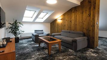 A modern living room with a wooden accent wall, a sofa, a coffee table, and a potted plant.