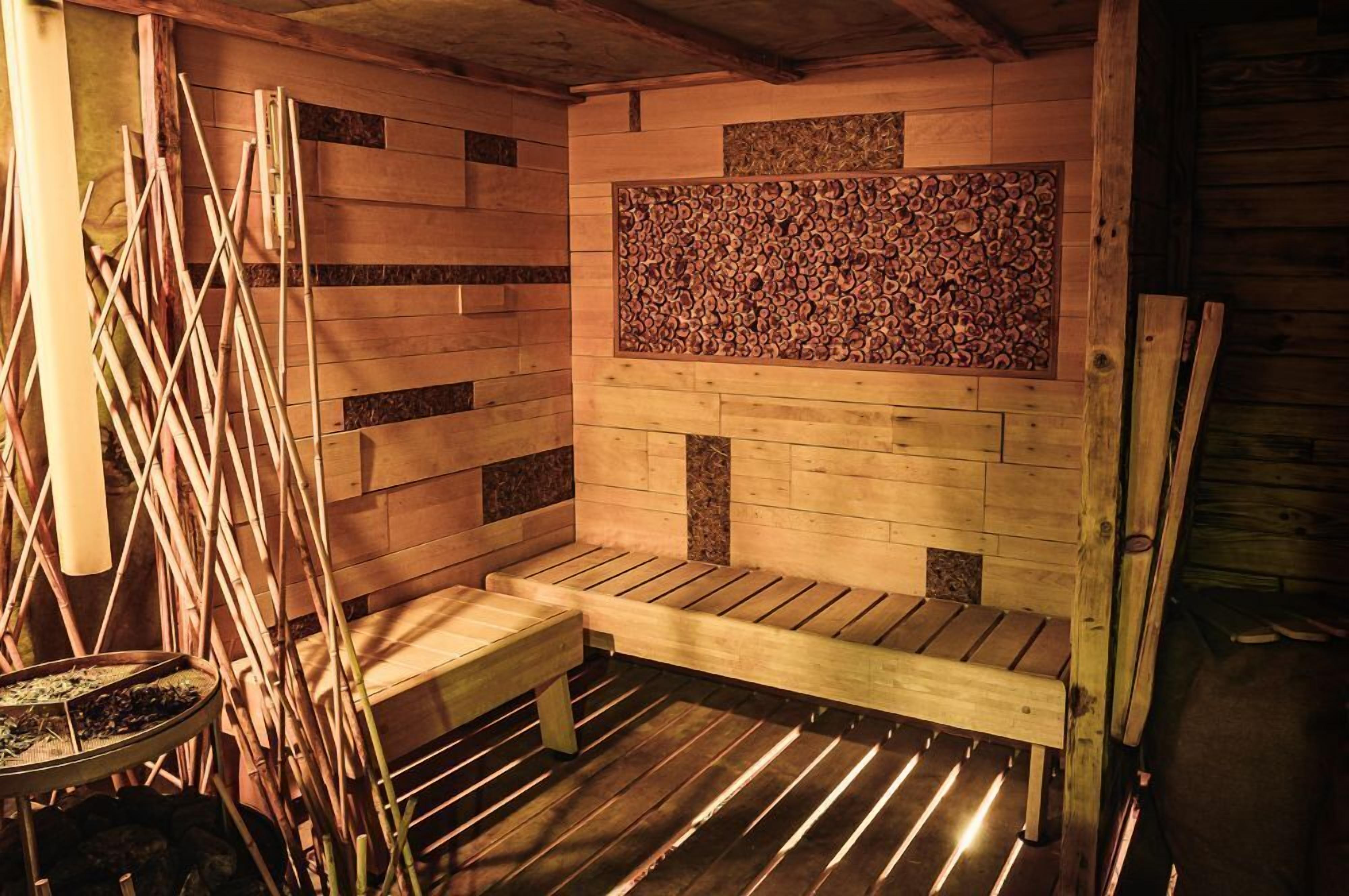 Una sauna con bancos de madera y una pared decorada con un diseño de incrustaciones de madera.