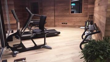 Una palestra con attrezzature per esercizi, pareti in legno e una finestra.