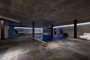 Una piscina techada, sillones reclinables de piscina