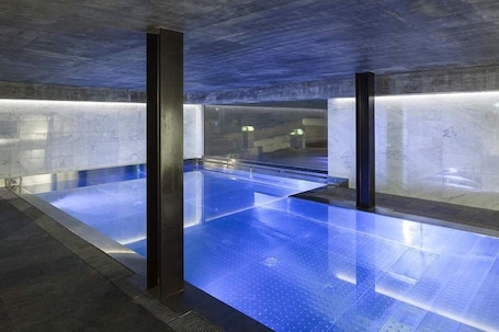 Una piscina techada, sillones reclinables de piscina