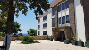 Un edificio moderno con fachada de piedra, ventanas amplias y vista al mar.