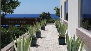 Un edificio con vista al mar, plantas en macetas y un letrero que dice "RESTAURANT".