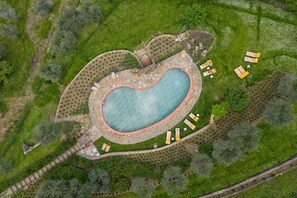 An aerial view of a heart-shaped swimming pool surrounded by stone pathways and lounge chairs. - La Pensione di Vignamaggio (Panzano in Chianti)