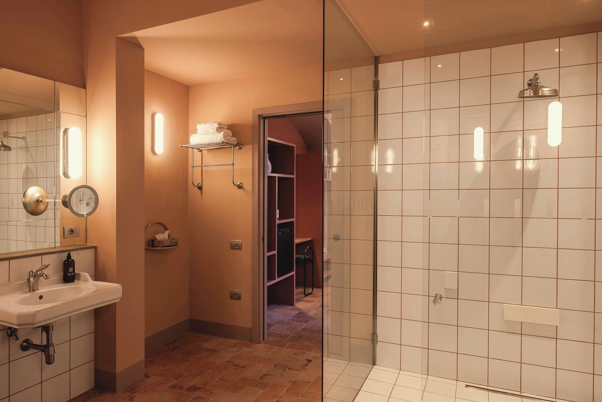 Ein modernes Badezimmer mit Waschbecken, Spiegel und einer Duschkabine.