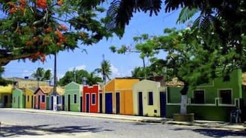 A row of colorful houses along a street with a clear blue sky.