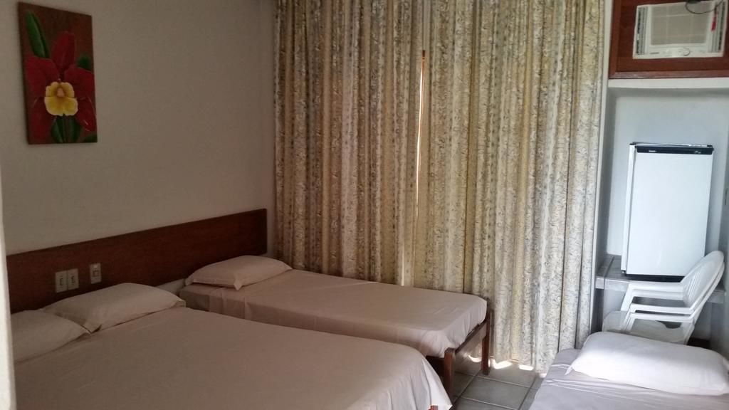 Habitación de hotel con dos camas, televisión y microondas.