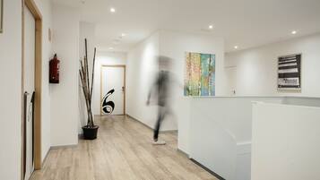 Een modern interieur met een houten vloer, een receptiebalie en een brandblusser aan de muur.