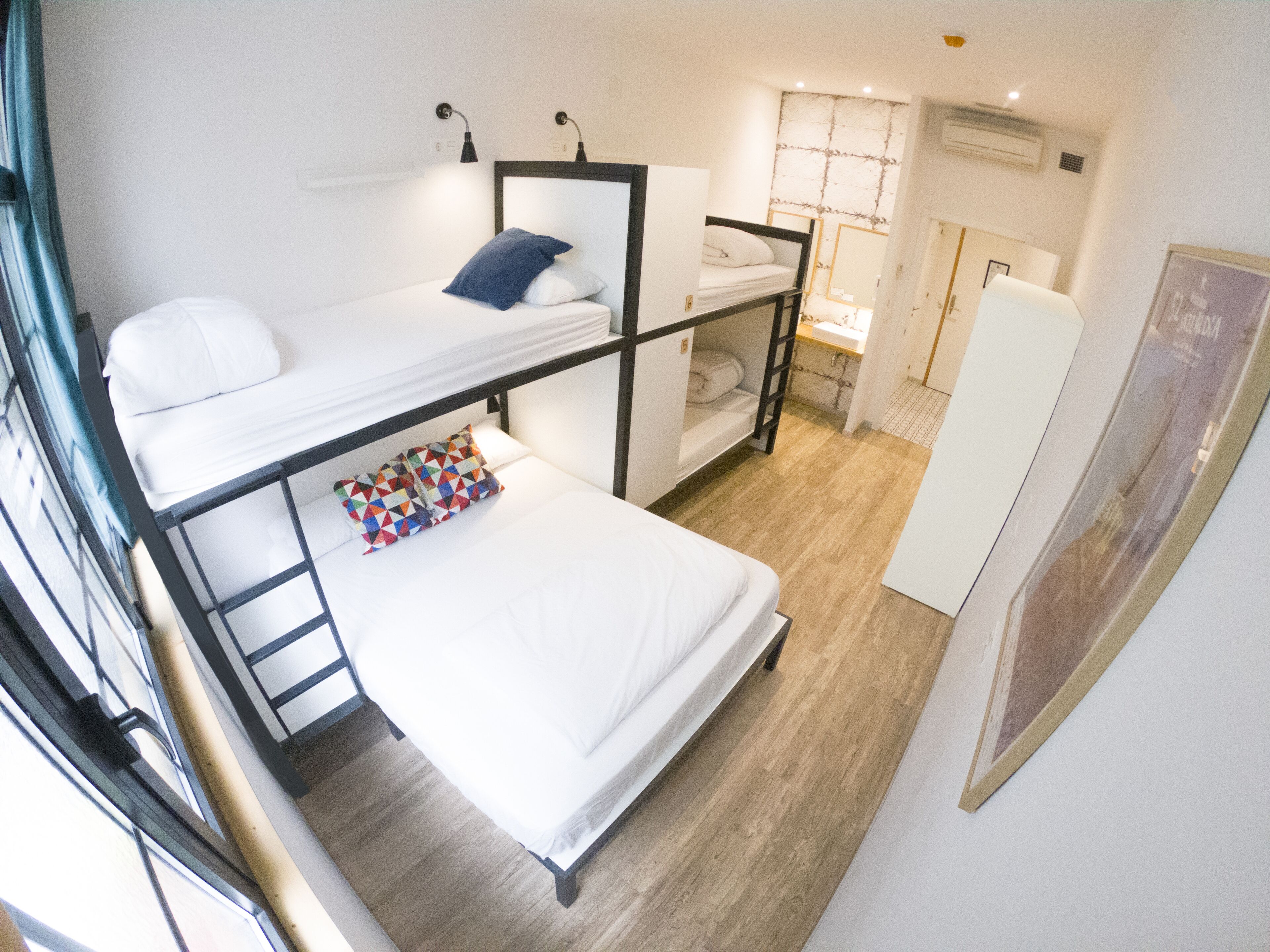 Una habitación tipo dormitorio con literas, un escritorio y una pequeña kitchenette.