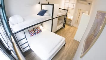 Una habitación tipo dormitorio con literas, un escritorio y una pequeña kitchenette.