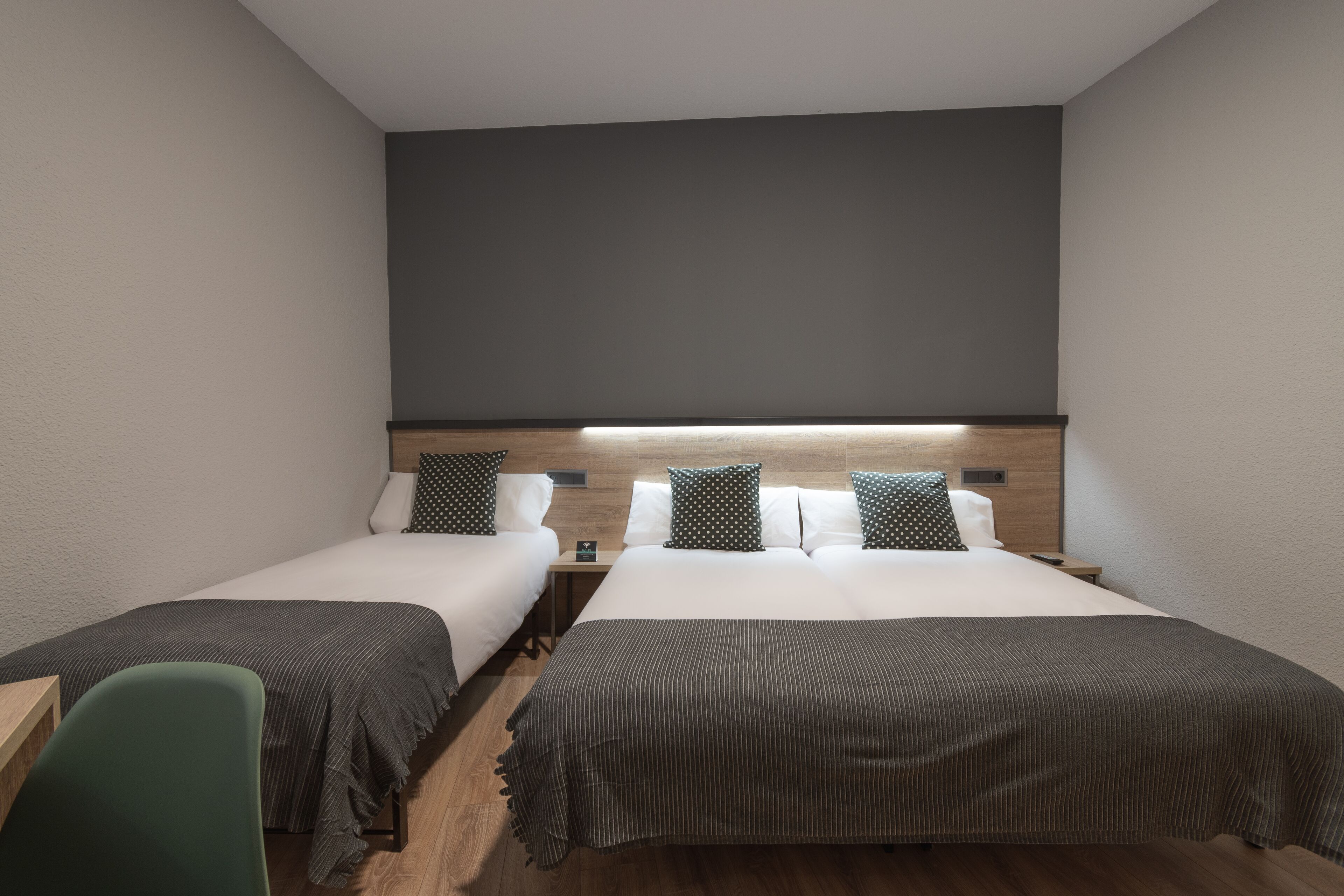 Habitación de hotel con dos camas, un escritorio y una silla.