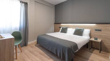 Ein modernes Hotelzimmer mit einem großen Bett, einem Schreibtisch und einem Stuhl.