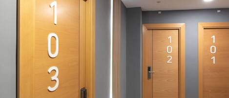 Un pasillo con puertas de madera numeradas 1, 2 y 3.