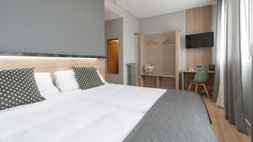 Une chambre d’hôtel moderne équipée d’un grand lit, d’un bureau, d’une chaise et d’un téléviseur.
