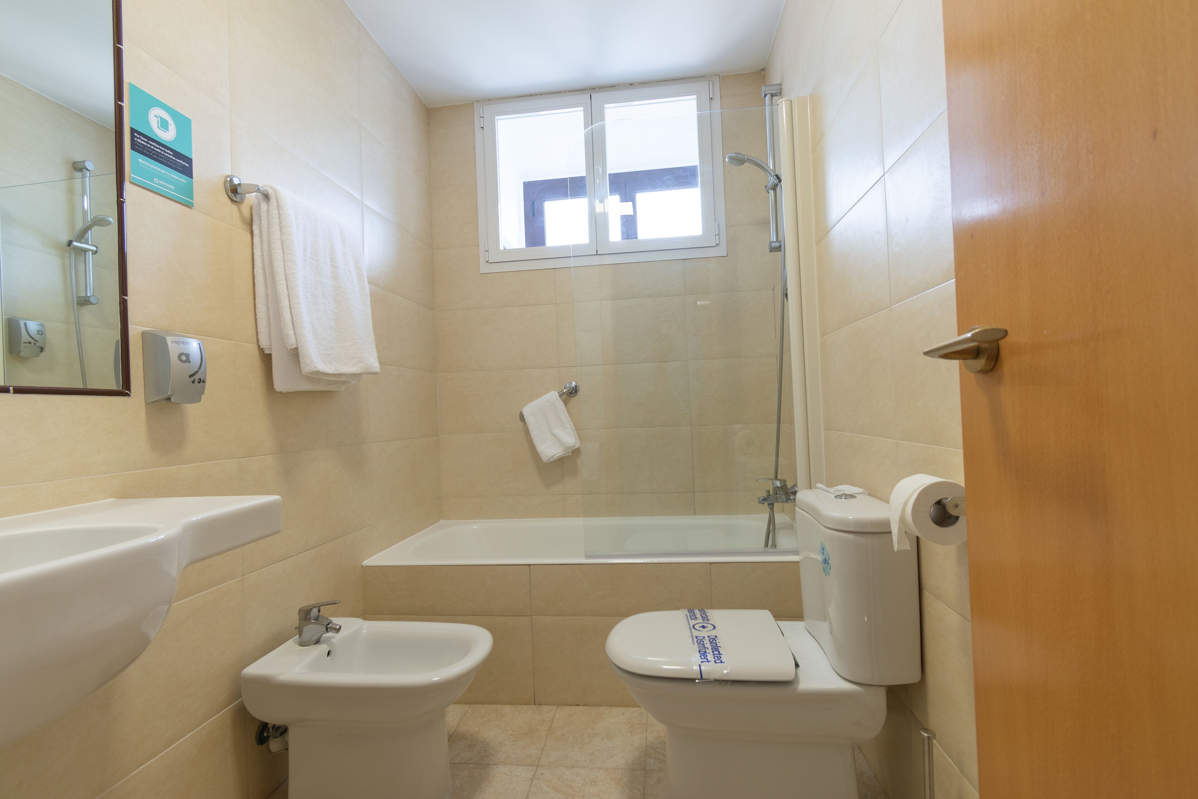 Un baño con bañera, dos lavamanos, inodoro y ducha.