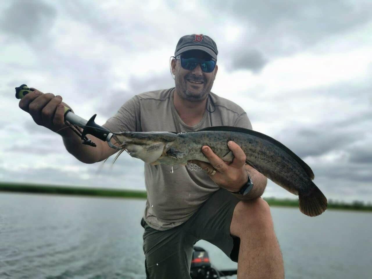 A person holding a fish on a boat.