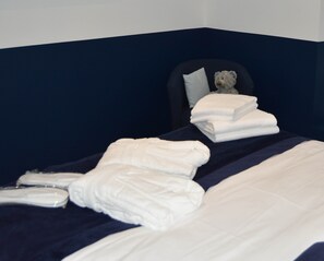 A neatly made bed with white linens and a teddy bear on the headboard. - Le Coteau de Bazeille (Sainte-Bazeille)