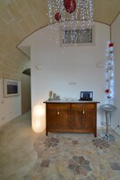 Una stanza con un armadio in legno, un portatile e un lampadario decorativo.