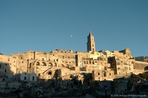 Paesaggio urbano storico con una torre imponente e numerosi edifici.